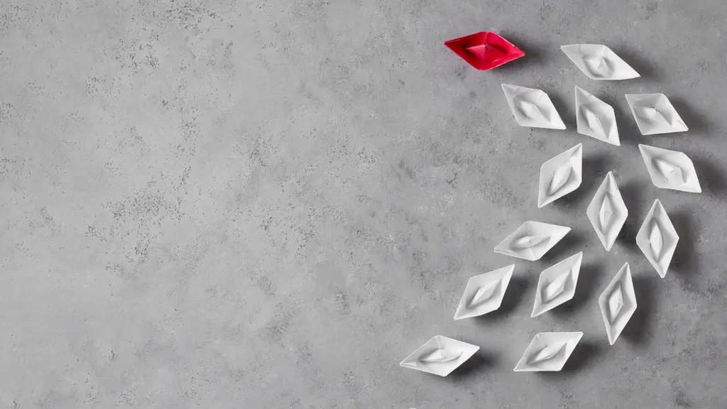 Barcos de papel em branco com um barco a frente vermelho. Representando o papel da comunica&ccedil;&atilde;o e lideran&ccedil;a