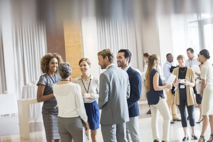 Comunicação Efetiva Executivos em auditório. em pé, exercitando o que aprenderam sobre comunicação efetiva.