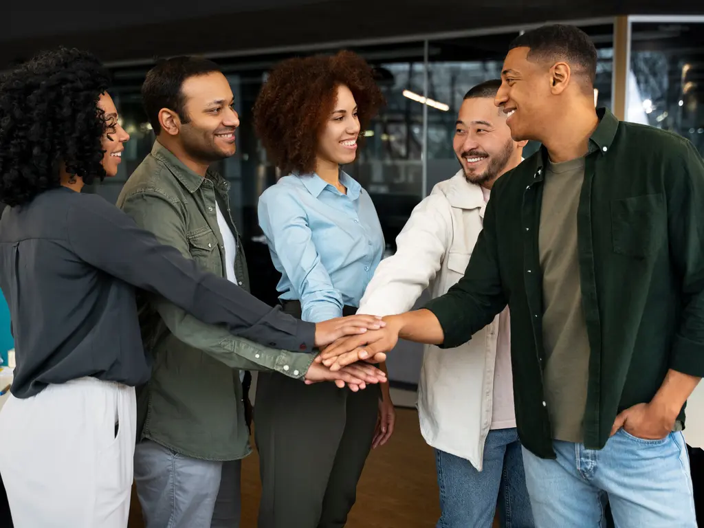 Prós e contras de uma liderança democrática. Equipe unida com mãos unidas - representando a forma de uma liderança democrática.